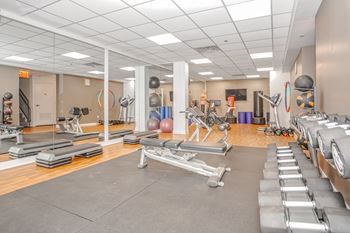 a gym with cardio equipment and weights on the floor